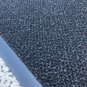 Close up product image of the bevelled edging and dual fibre loop pile, arranged in a pattern to hide dirt.