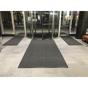 Image of a superguard entrance mat being used in a building lobby. Also shows how it can be installed into revolving doors.
